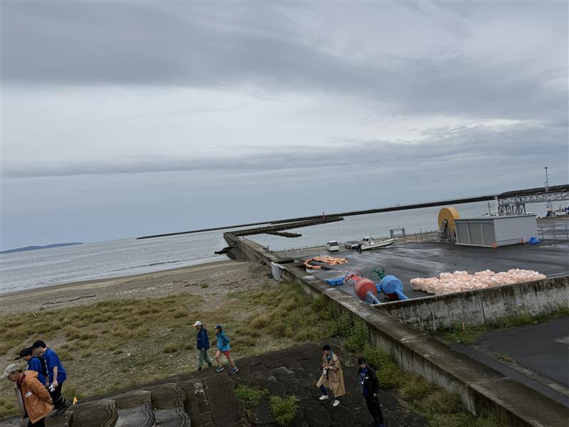渡波海水浴場の全景。曇り空の下、砂浜へ向かう参加者たち