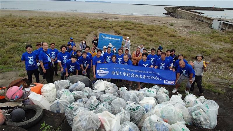 渡波海水浴場で回収したごみ袋の前に並ぶ参加者の集合写真